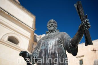Een standbeeld in Malta van een man met een boekrol