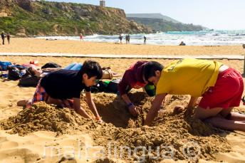 Groepsleider en studenten amuseren zich op het strand