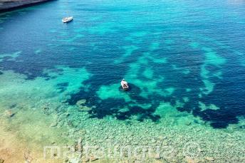 Gezicht op een baai in Malta met helder aquamarijn water