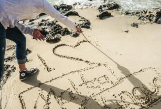 Een student schrijft in het zand