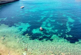 Gezicht op een baai in Malta met helder aquamarijn water